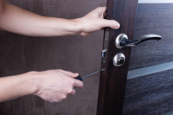 To hender som skrur på håndtak på en dør